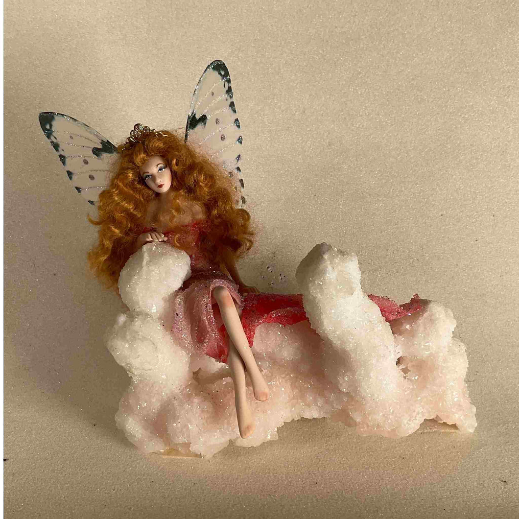 Hand made porcelain fairy sitting on stilbite.